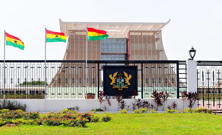 Modern government building with Ghanaian flags and national coat of arms